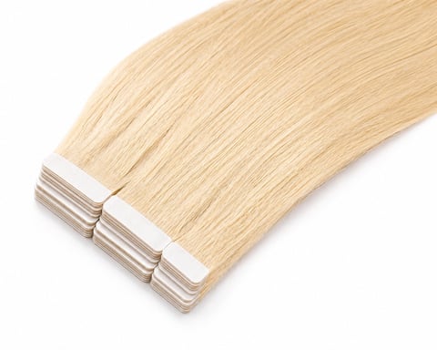 Blonde hair extension strips with adhesive tabs on white background