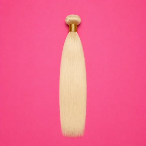 Blonde human hair extension bundle with golden clip against bright pink background